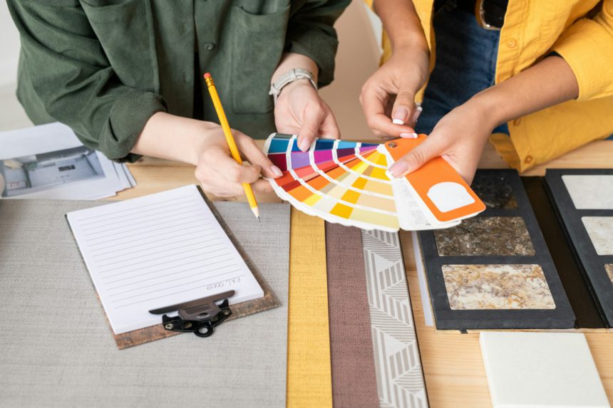 Hands of two young female interior designers consulting about choice of color