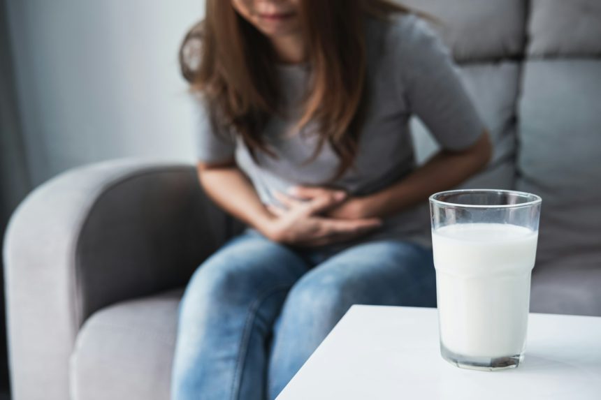 Woman having bad stomach ache with a glass of milk, Lactose intolerance, health care concept